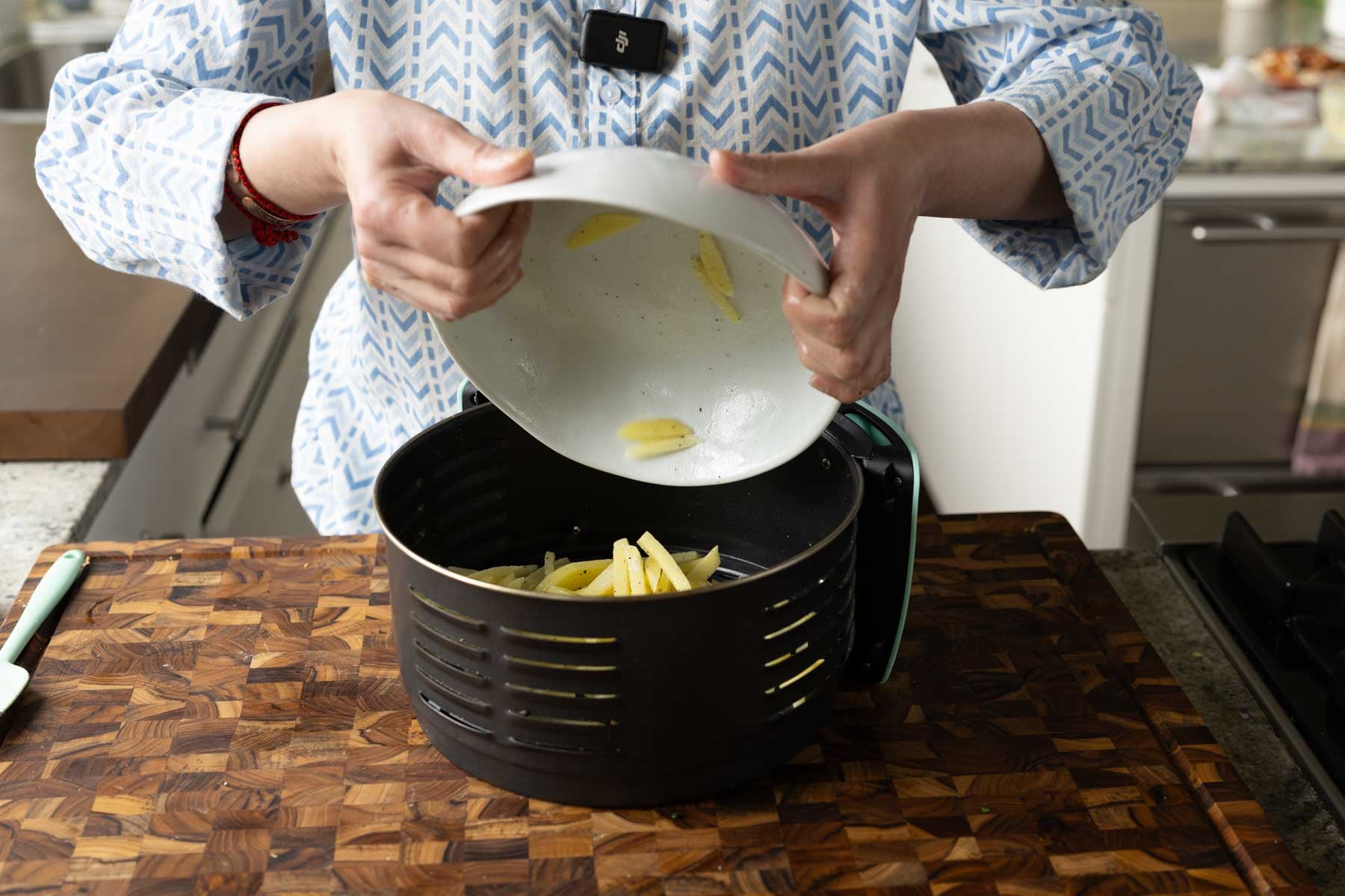 adding the potatoes to the air fryer