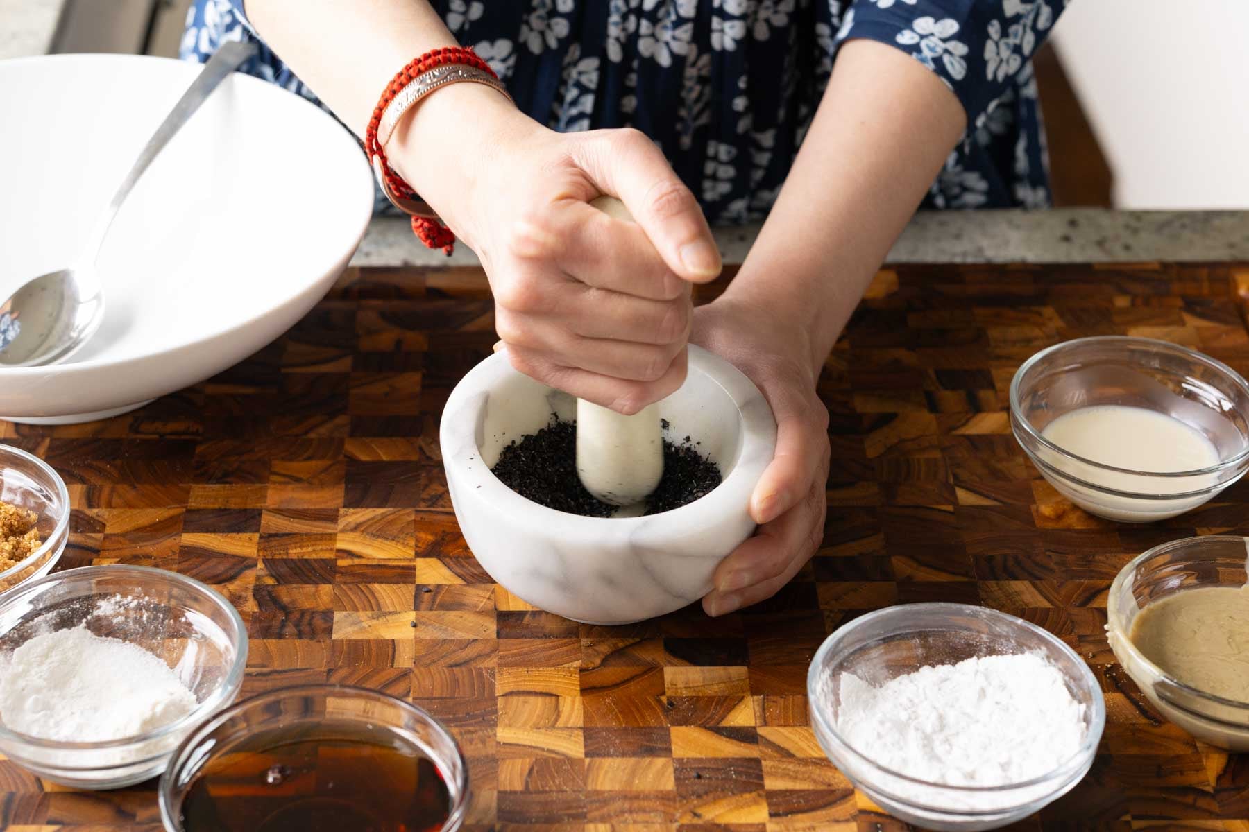crushing the black sesame seeds in a mortar and pestle