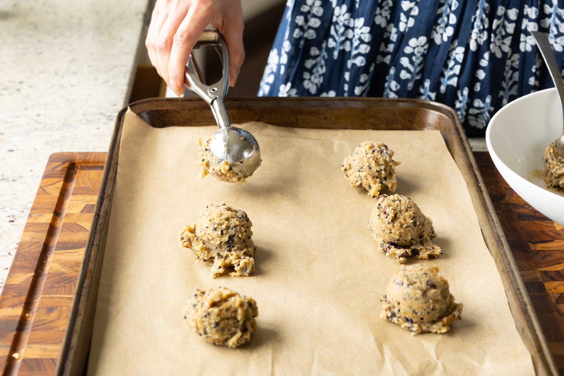 scooping the cookie dough onto the lined baking sheet