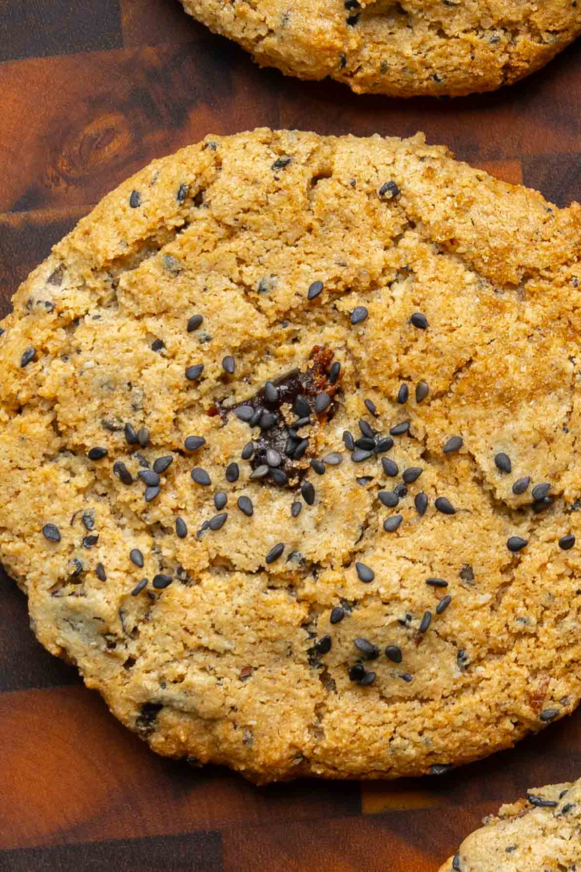 close-up of a black sesame cookie on a wooden cutting board