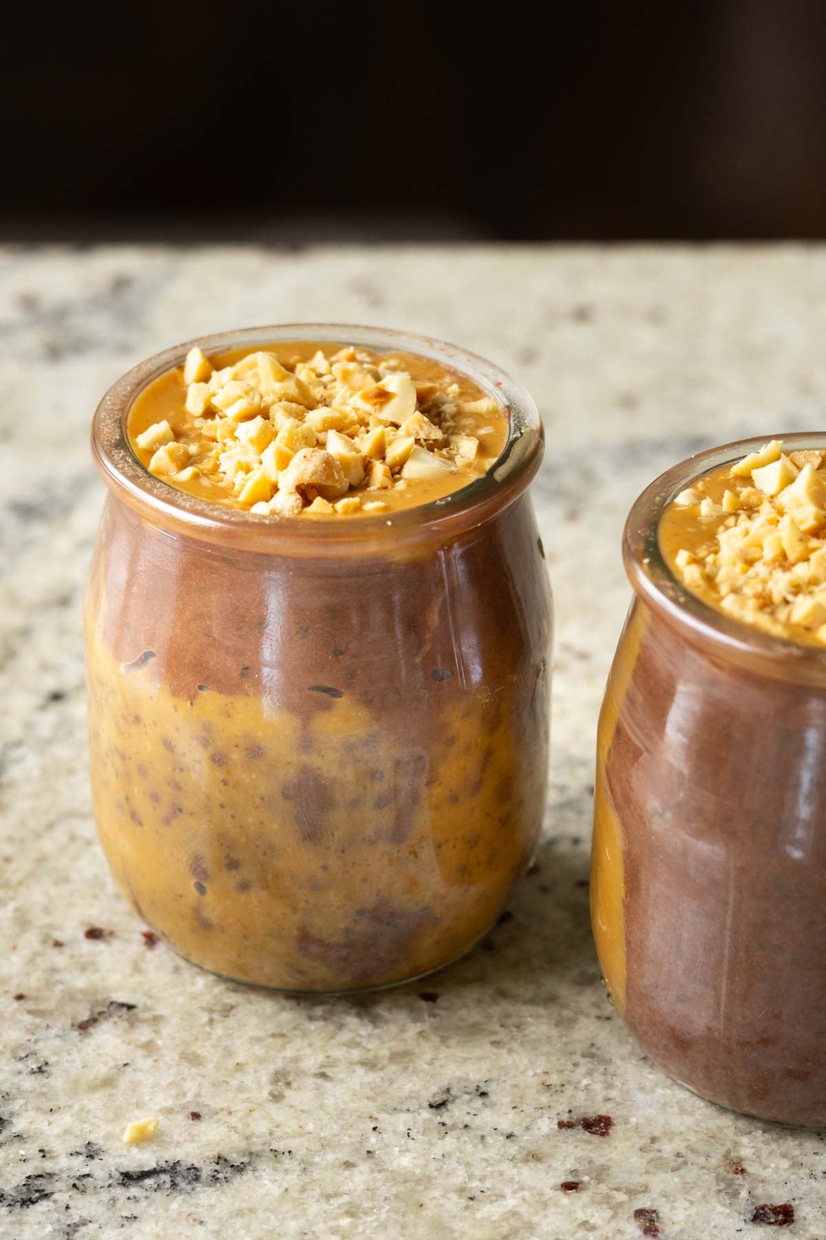 whipped tofu chia pudding with chocolate and peanut butter in jars on the kitchen counter