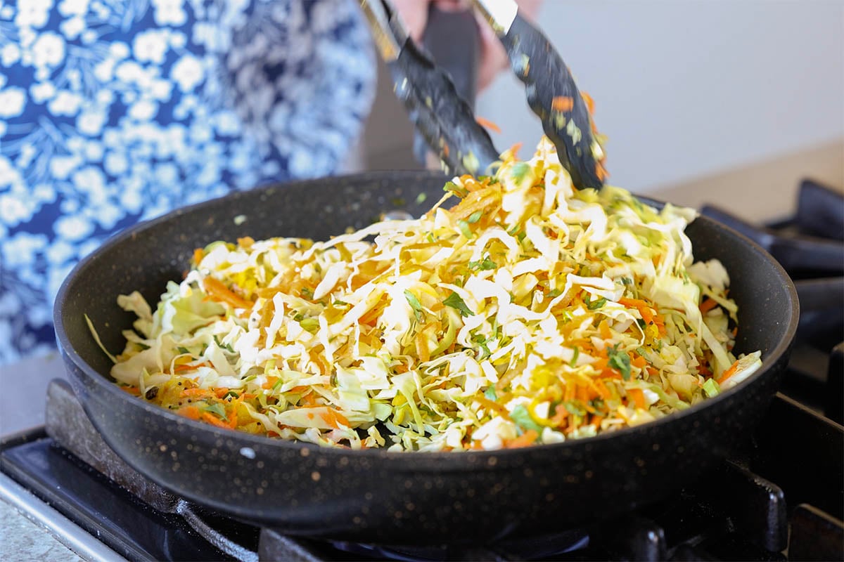 tossing the veggies in the spiced oil
