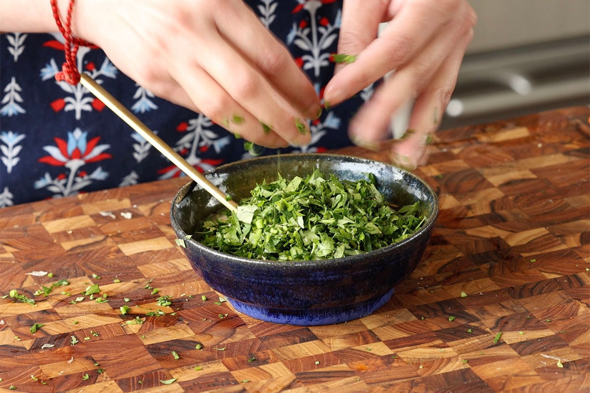 adding cilantro to the yogurt sauce