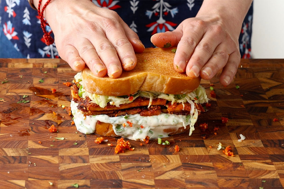 coconut tofu sandwich on a cutting board after assembling