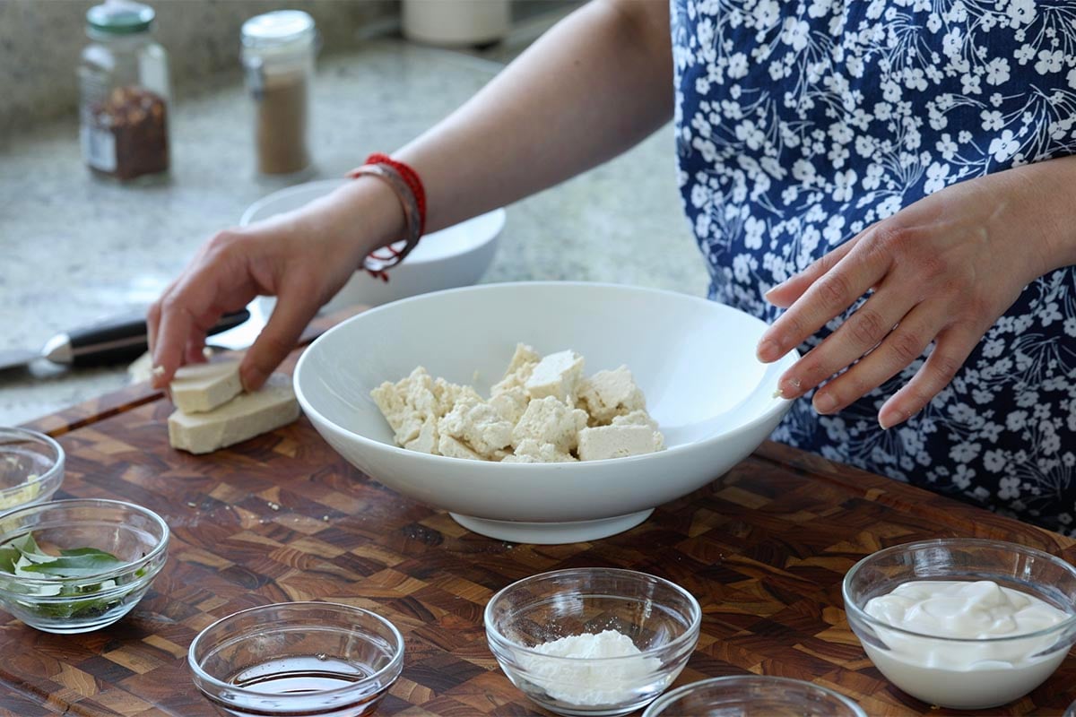 tearing the tofu into bite sized pieces