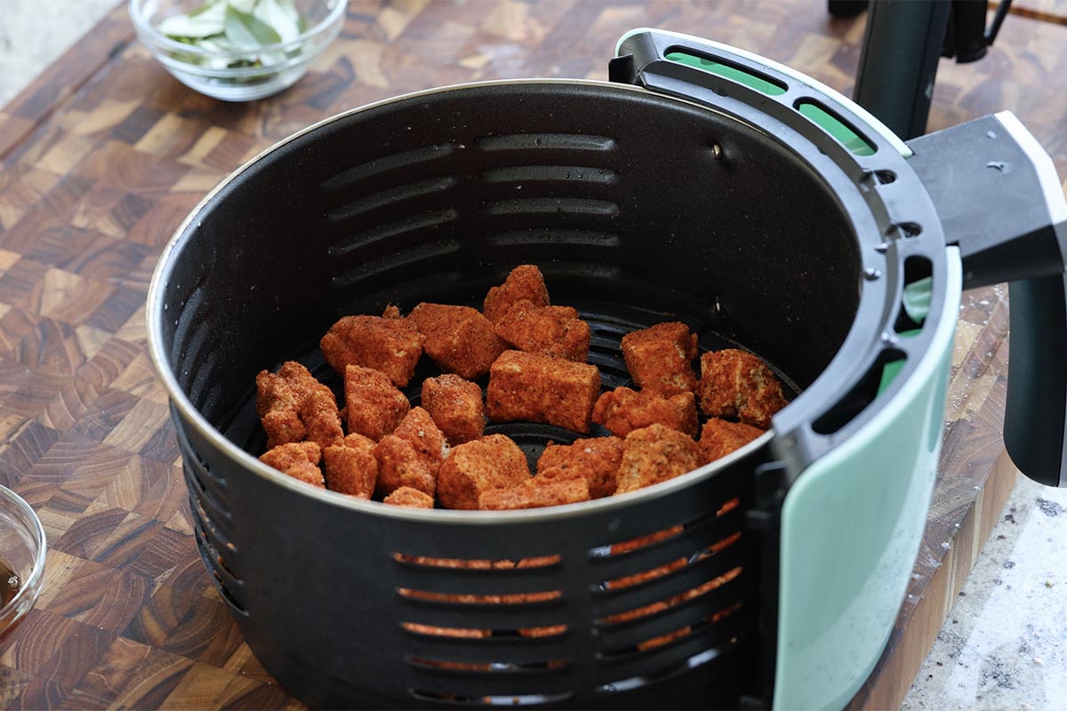 adding the tofu pieces to the air fryer