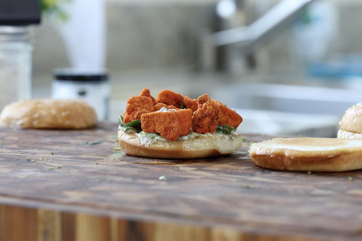 adding greens and tofu to the bun