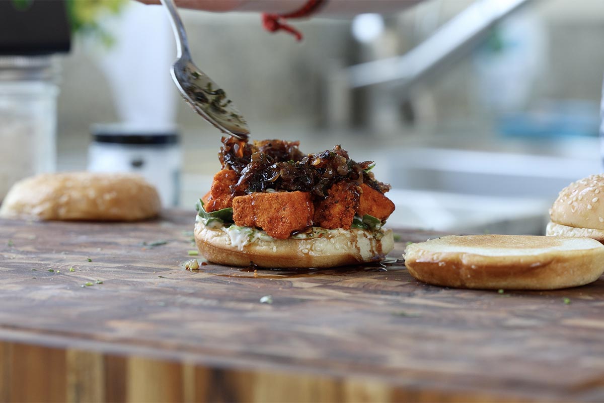 spooning curry glaze onto the sandwich