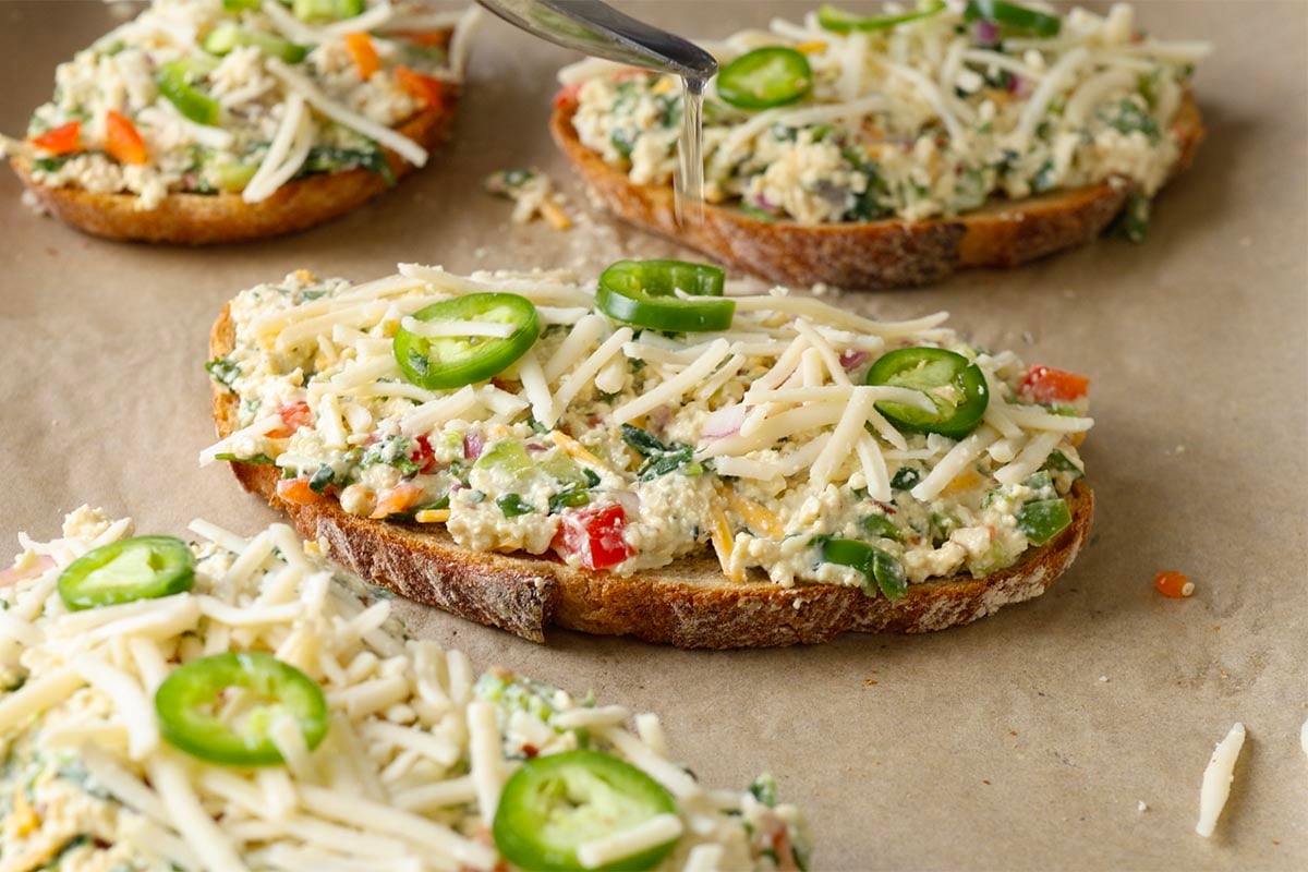 chilli cheese toasts topped with cheese shreds and sliced green chillies