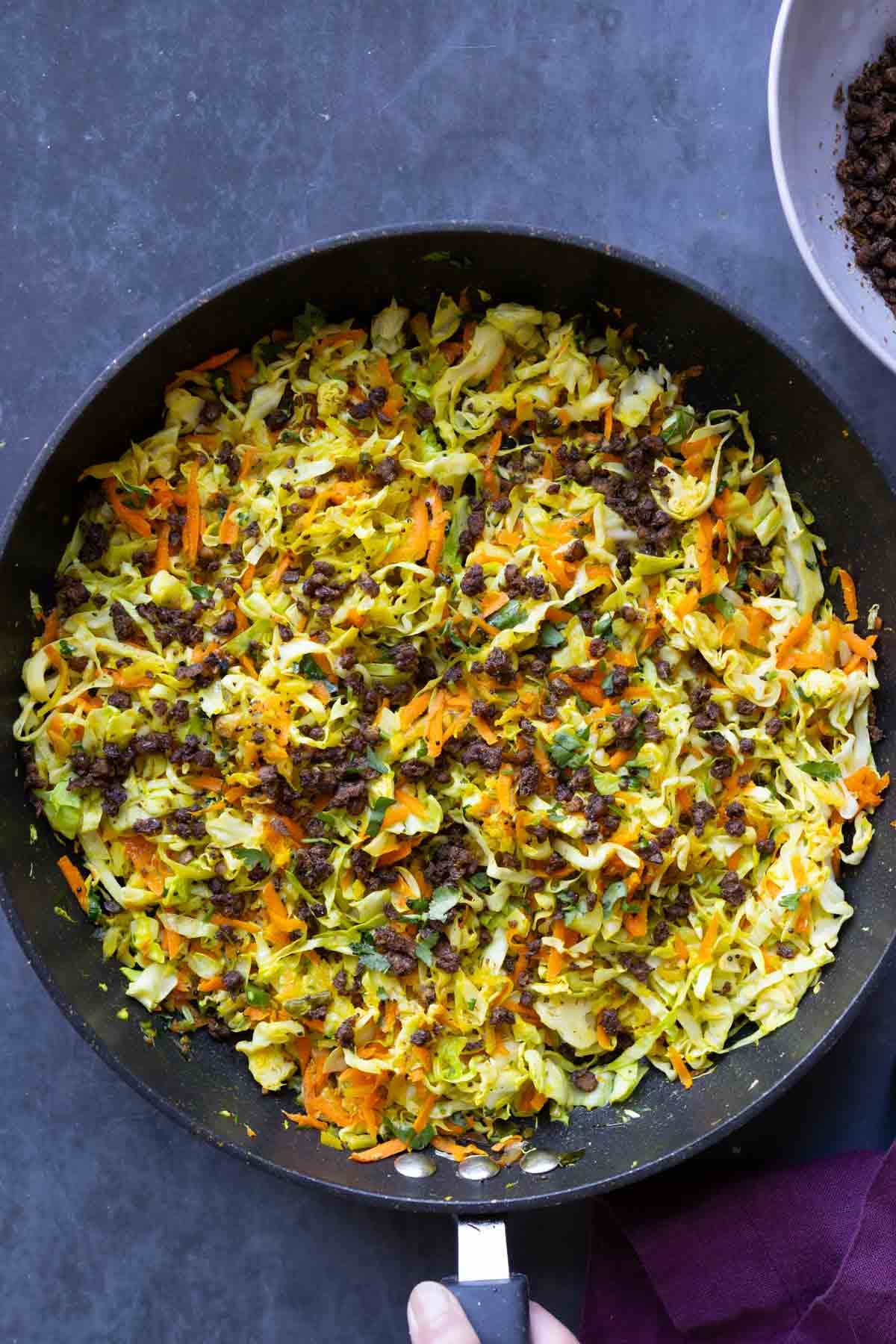 Indian cabbage salad in the pan after adding toppings