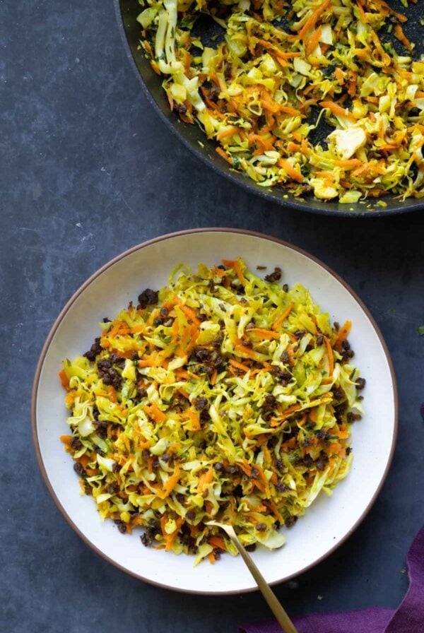 bowl of sambharo-inspired cabbage salad next to the pan