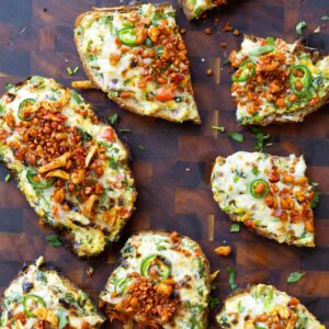 Indian chilli cheese toasts on a cutting board with some sliced in half