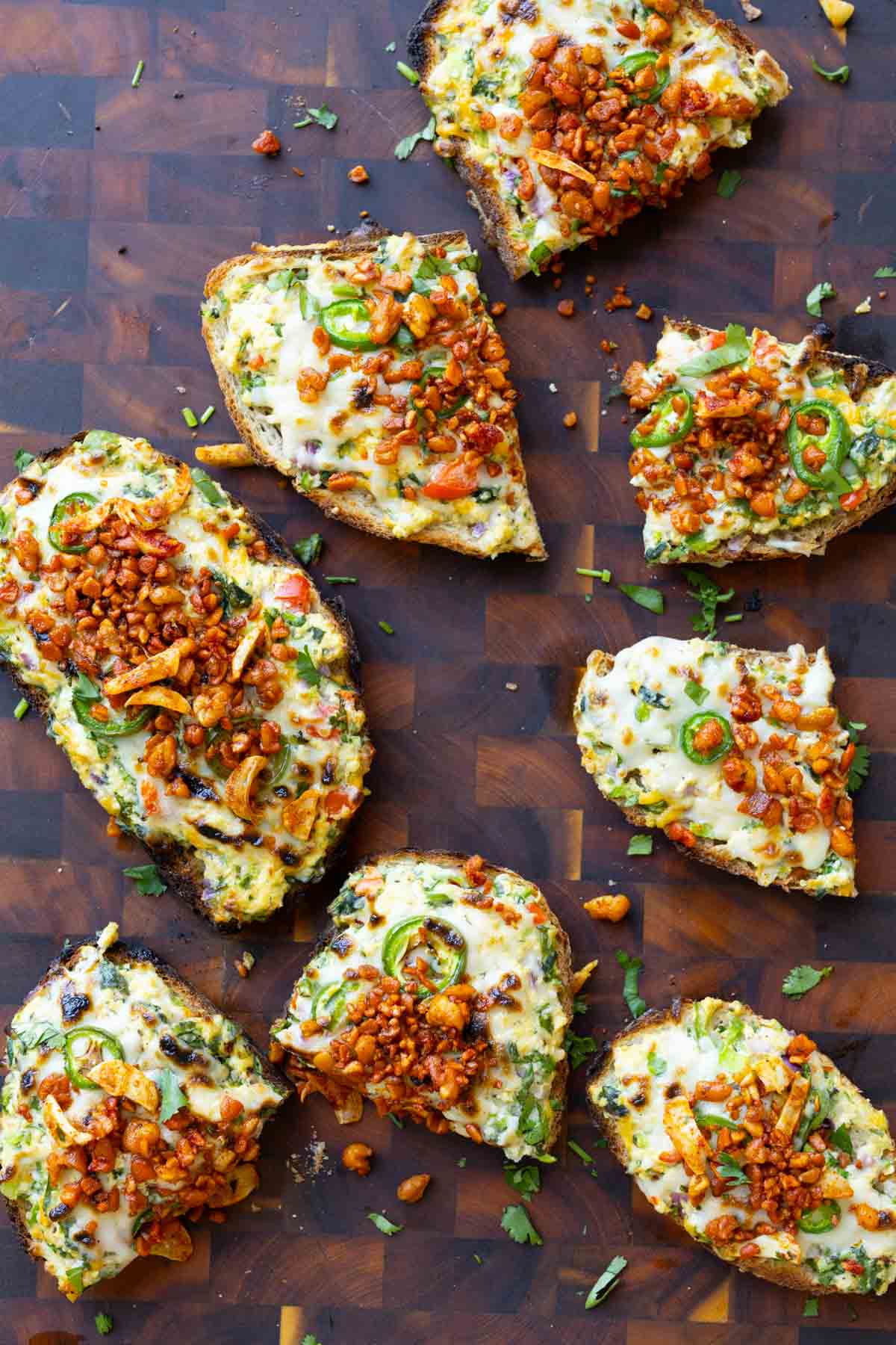 Indian chilli cheese toasts on a cutting board with some sliced in half