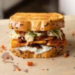 coconut tofu sandwich on a cutting board after assembling