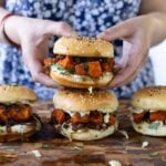 hands picking up a curry glazed tofu sandwich