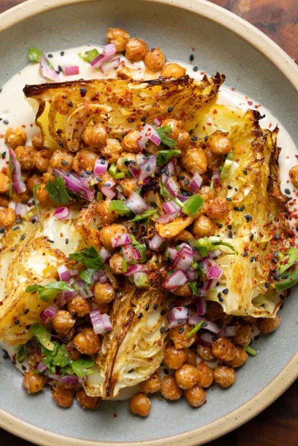 roasted cabbage wedges on a bed of tahini sauce with crispy chickpeas and gremolata