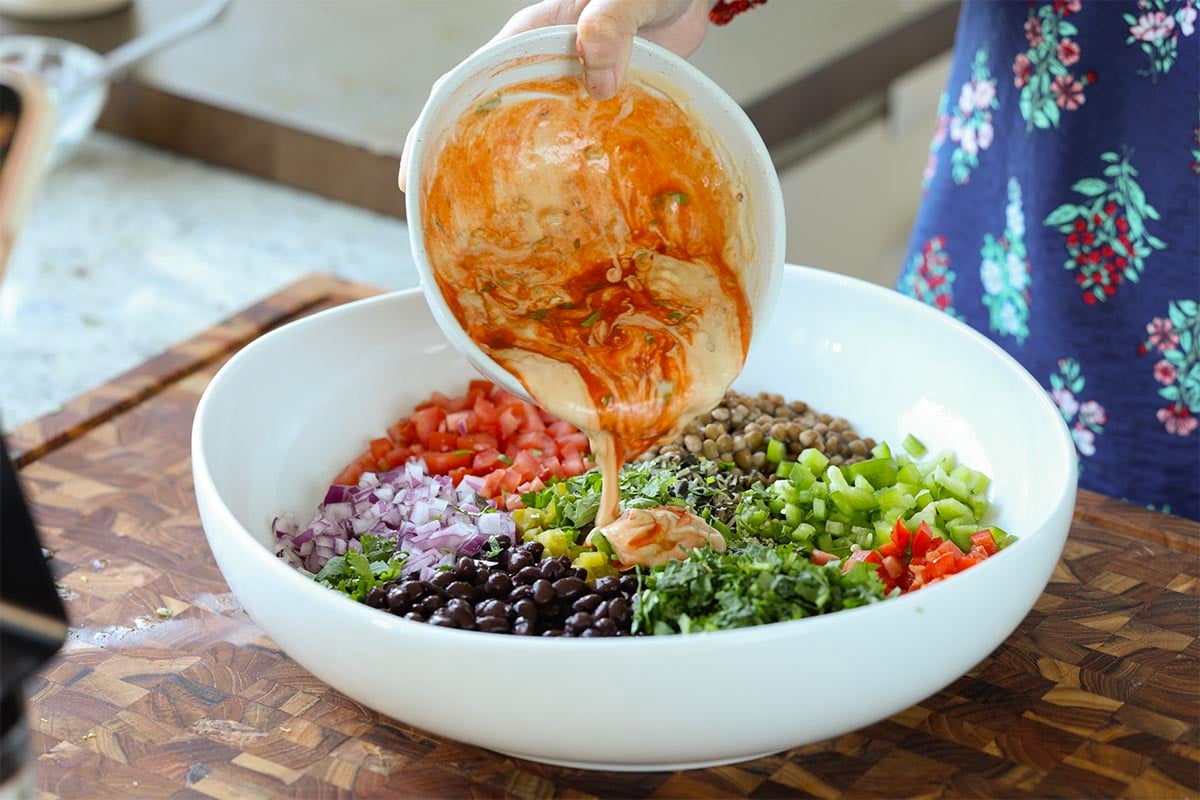 pouring the dressing onto the salad