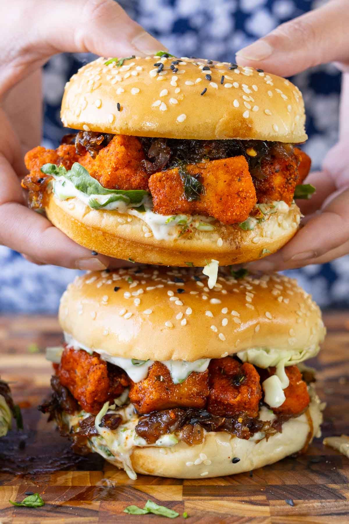 close-up of hands holding the crispy curry tofu sandwich